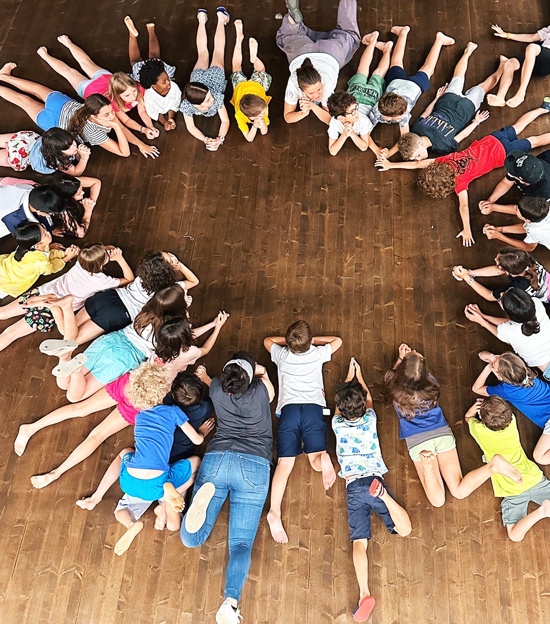 Bambini in cerchio durante un laboratorio di teatro in un campus estivo a Milano